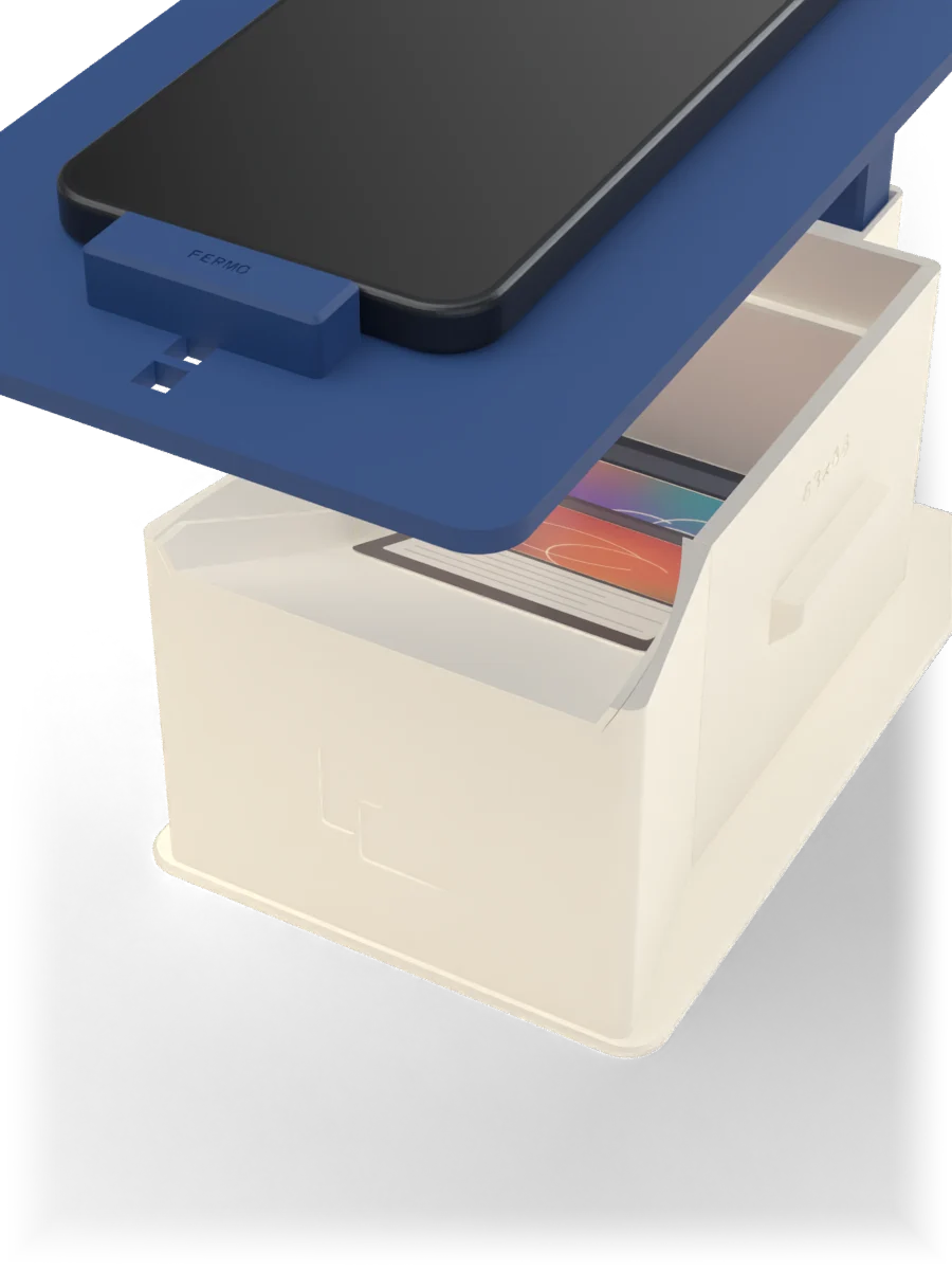 Una carta scende sulla rampa a imbuto e cade nel cassetto, sotto la fotocamera del telefono.